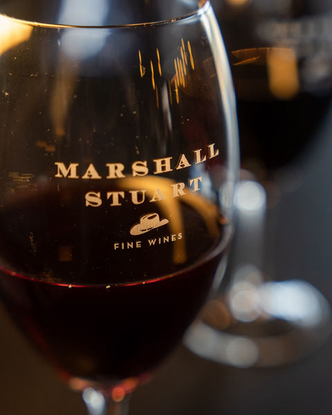 Marshall Stuart Fine Wines in a dark red glass close up, very classy