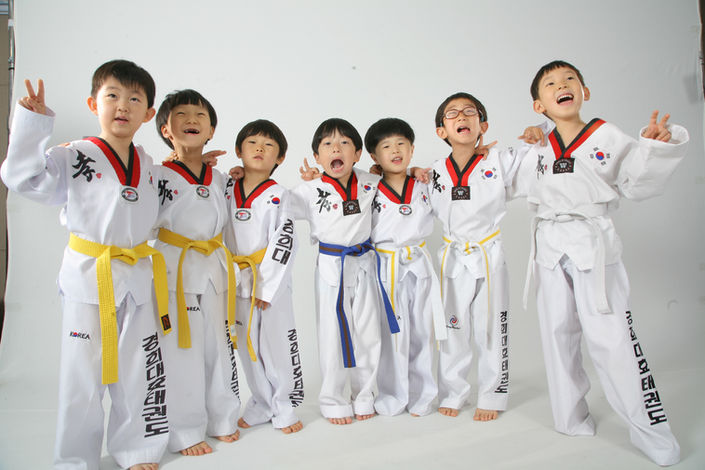 Happy Taekwondo kids smiling holding up two fingers at Vail Headquarters