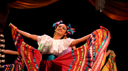 Woman in vibrant traditional Mexican dress dances joyfully