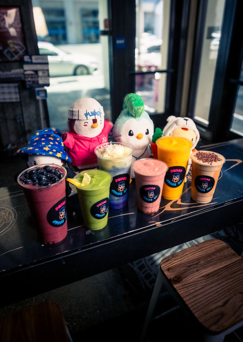 Colorful smoothies and stuffed toys on a counter at Riverside Food Lab.
