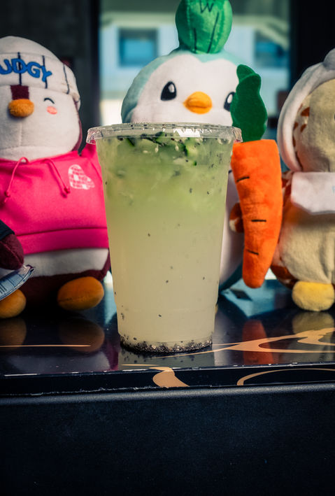 Refreshing drink in a clear cup with cute penguin toys in the background.