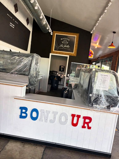 Cafe counter with BONJOUR sign and plastic-covered equipment