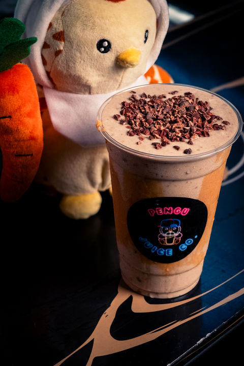 Smoothie with toppings next to a stuffed animal, visible text, Riverside Food Lab.
