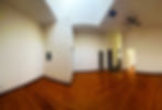 Union Building Apartment C interior view with wooden floors, white walls and partition and ceiling fan