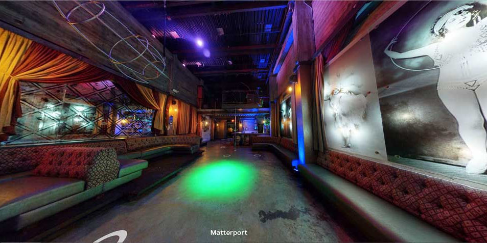 wide-angle view of the Flyway Lounge interior with booths, green light, and 20's flapper wall image at the Fox Theater in Pomona