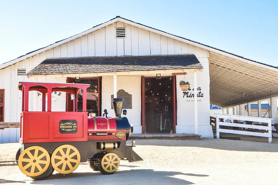 Red mini-train engine outside Vail Milk House at Temecula
