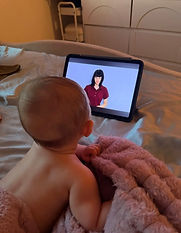 A baby watching Ms Raven on a tablet