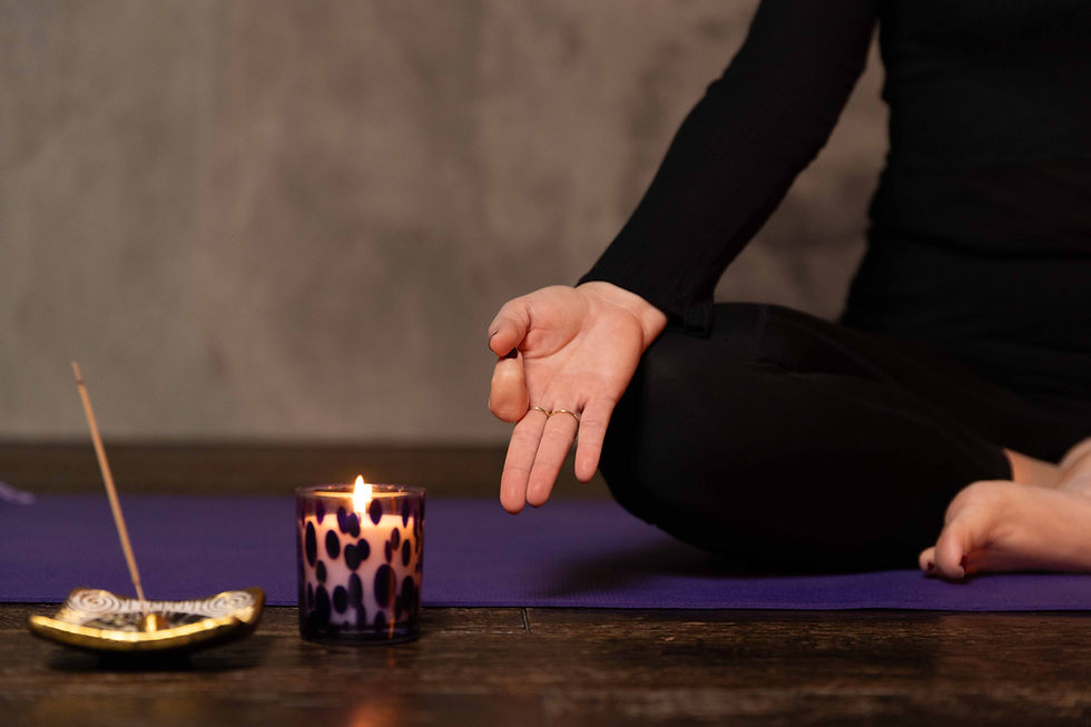 Persona in meditazione yoga con candela e incenso