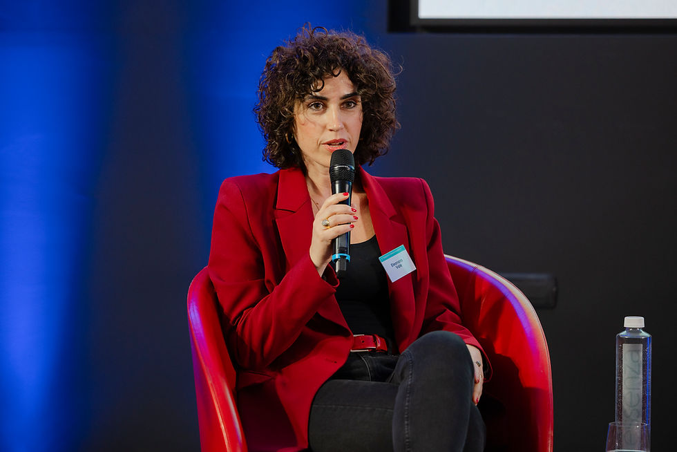 Donna con giacca rossa parla di benessere a una conferenza