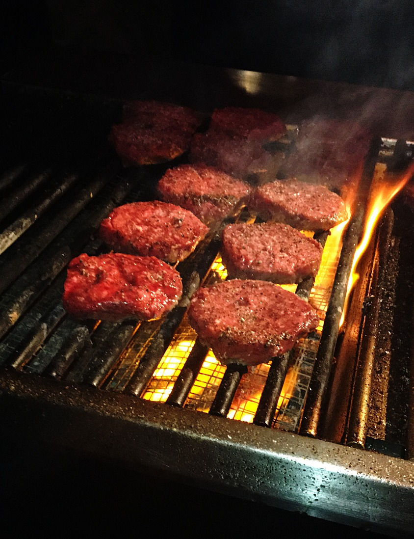 FIRE IT UP! Burgers being flame broiled on the grill.