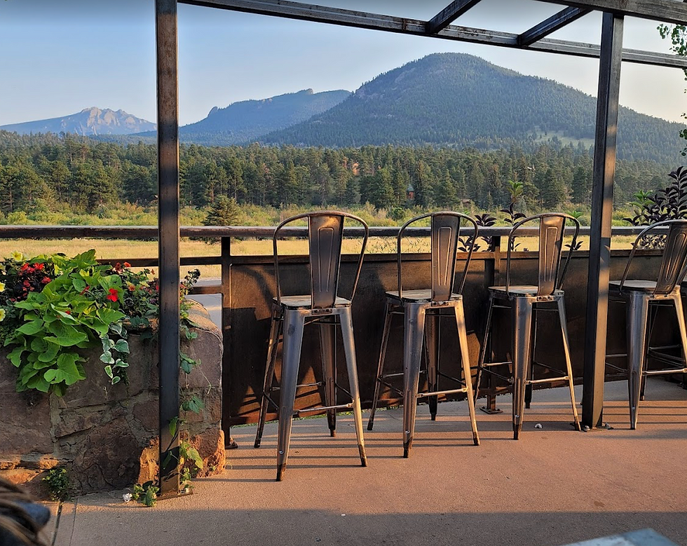 Metal chairs and bar overlooking a mountain scene.