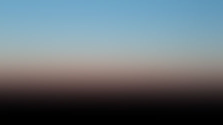 Céu ao entardecer, em degradê azul e rosa sobre um horizonte escuro e silencioso.