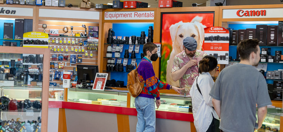 Customers browse cameras and equipment at The Shutterbug camera store, Canon, Nikon.