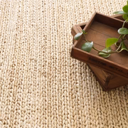 Neutral natural fiber rug can be paired with a statement piece for a sophisticated layered look.
