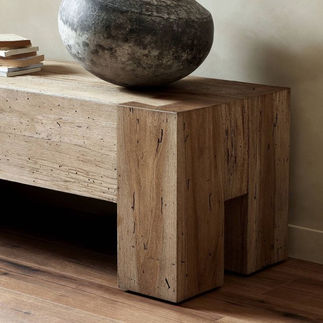 A reclaimed wood side table with a natural stone decor element showcases how to incorporate rustic yet modern design elements in home interiors.
