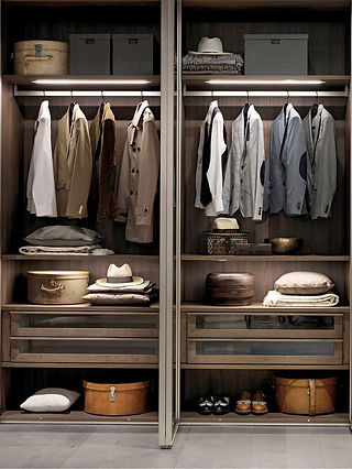 Gentleman’s dream closet with hanging space, drawers, and spots for storing hats and shoes.