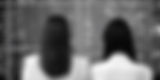 business 2 women backs looking at technology data board black and white closer to their ba