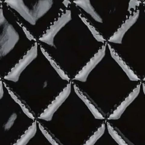 Close-up of a Chanel Classic Flap bag showing the patent leather material