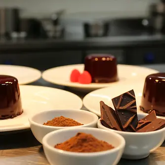 Angerichtete Schokotörtchen mit Himbeeren, Schokolade und Kakaopulver als Symbol für professionelles Dessertfinale und operative Unterstützung in der Küche