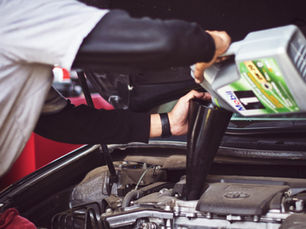 Man pouring oil into car's engine