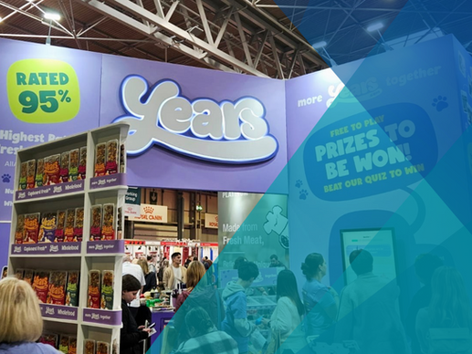A purple exhibition stand for "Years", a pet food brand. There are shelves of packaged dog food, and a proscenium arch in the centre of the stand. It reads "Rated 95%" in a big green bubble, and "Prizes to be Won" in a big purple bubble. The photograph is partially covered over by teal triangles, representing Image Experiential's Brand Colours