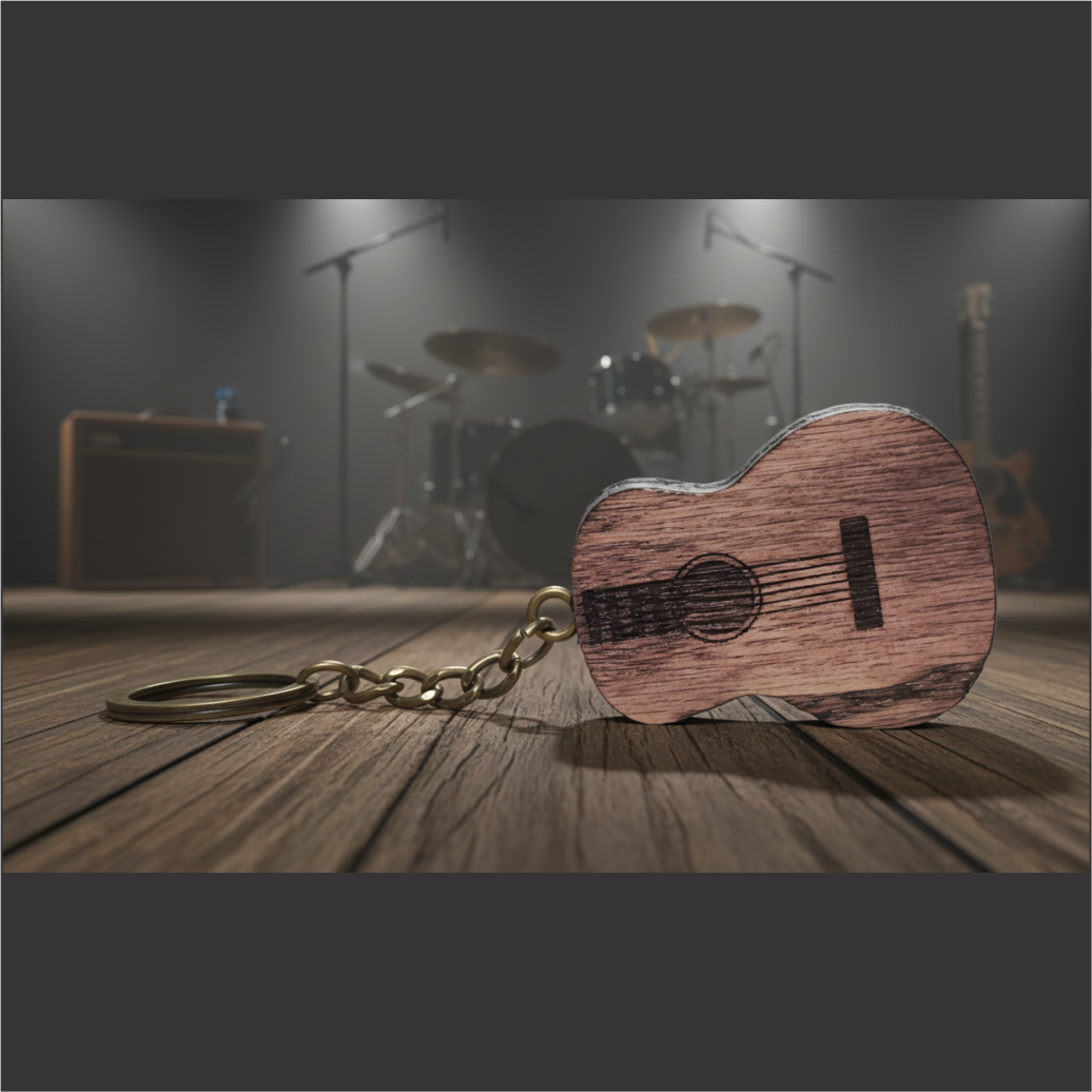 Wooden guitar keychain resting on stage, with drums and amp in background.
