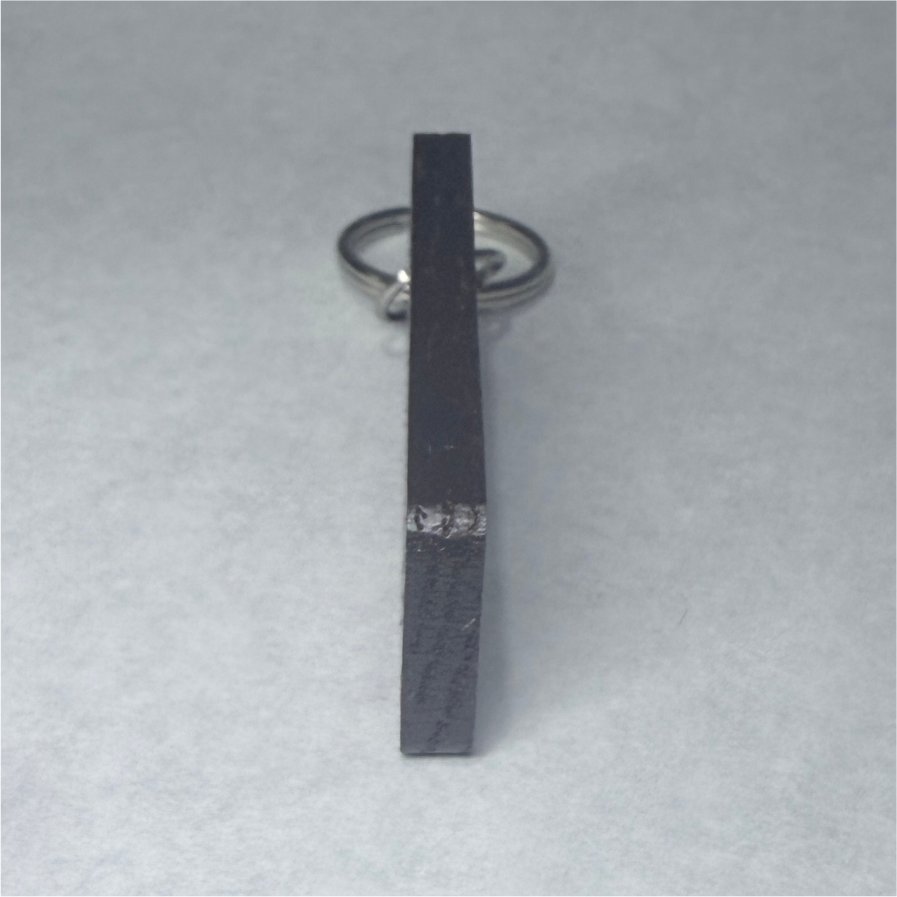 Thumbnail: Dark wood rectangular keychain with a shiny silver metal ring attached.