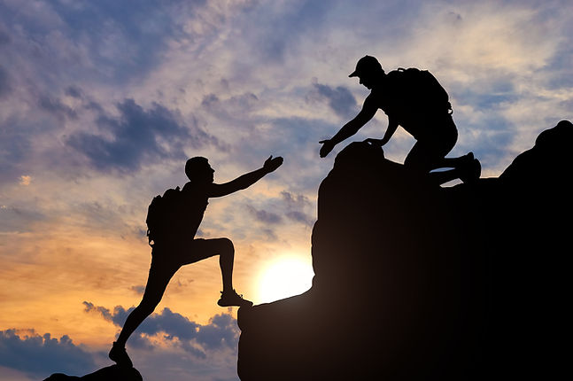 silhouette-male-mountaineer-working-team-with-partner-giving-him-helping-hand-concept-help