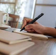 closeup-image-hand-writing-blank-notebook-with-coffee-cup-table-cafe_edited.jpg