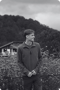 A picture of our founder, Alex, in front of a meadow