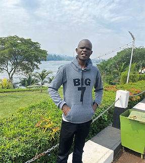 One of mount elgon eco tours guides in a grey hoodie standing by a lake