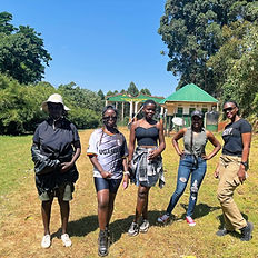 Five women pose outdoors in grassy Mount Elgon National Park.