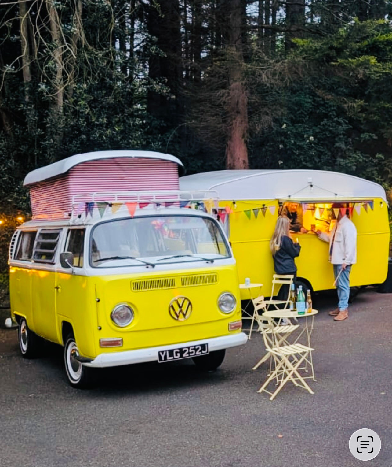 Vintage yellow VW Campervan and classic beetle parked side by side at a festival wedding, campervan's sliding door open, showing relaxed festival atmosphere