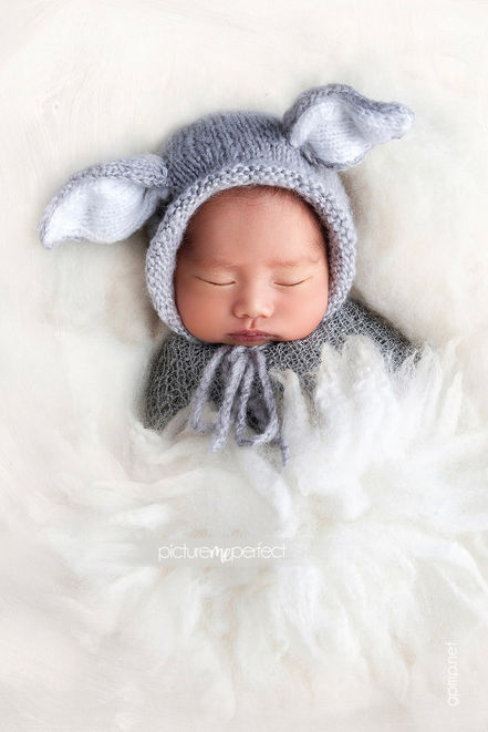 Newborn baby boy sleeping in white wool with a grey bunny knitted bonnet. Canarias at Downtown Doral