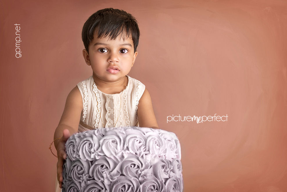 Toddler holding a gray rosette cake west miami