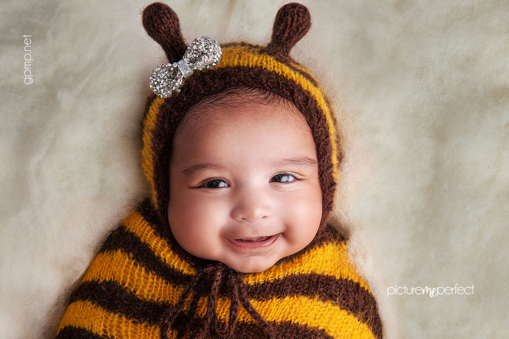 newborn Smiling baby girl in a bee costume with a sparkly bow .Miami The Ridges photo shoot