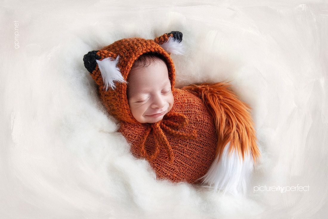 Smiling newborn in a fox crochet outfit on a white wool, At the comfort of your home in Miami, Westchester