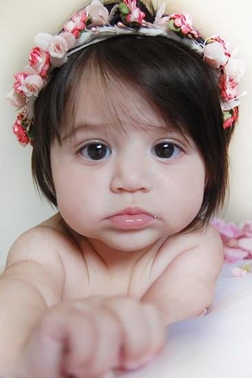 Awake newborn with a flower headband looking curious, In-Home photo shoot at Miami , Doral