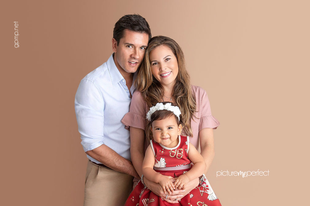 Smiling family portrait in studio with young daughter
