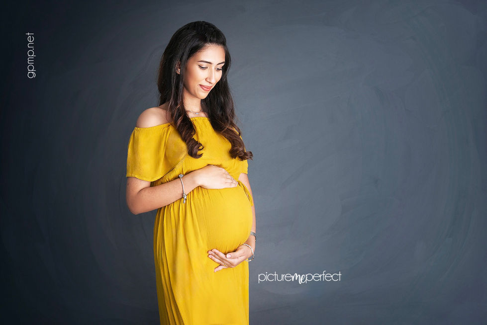 Pregnant woman in yellow dress holding her belly. Westchester,Coral Way corridor