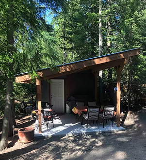 Covered deck at Cabin Two with outdoor dining table and seating for six at Hummingbird Cabins 'n' Breakfast