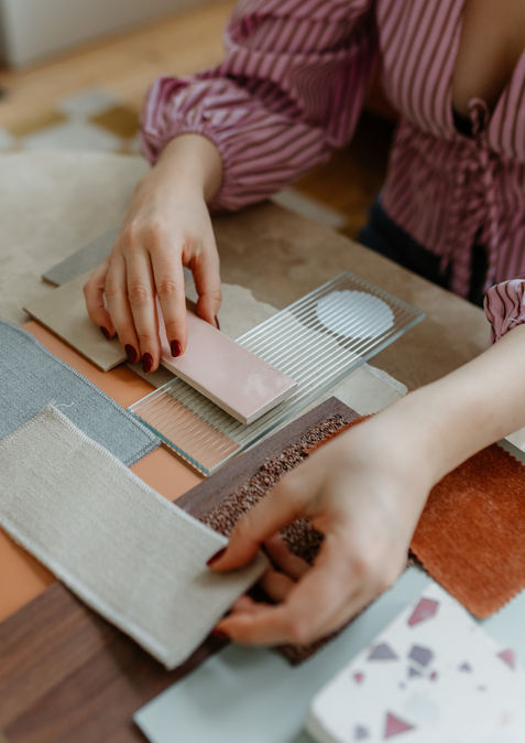 Charlotte Claesen legt verschillende stoffen, tegels en materialen samen op tafel voor een project.