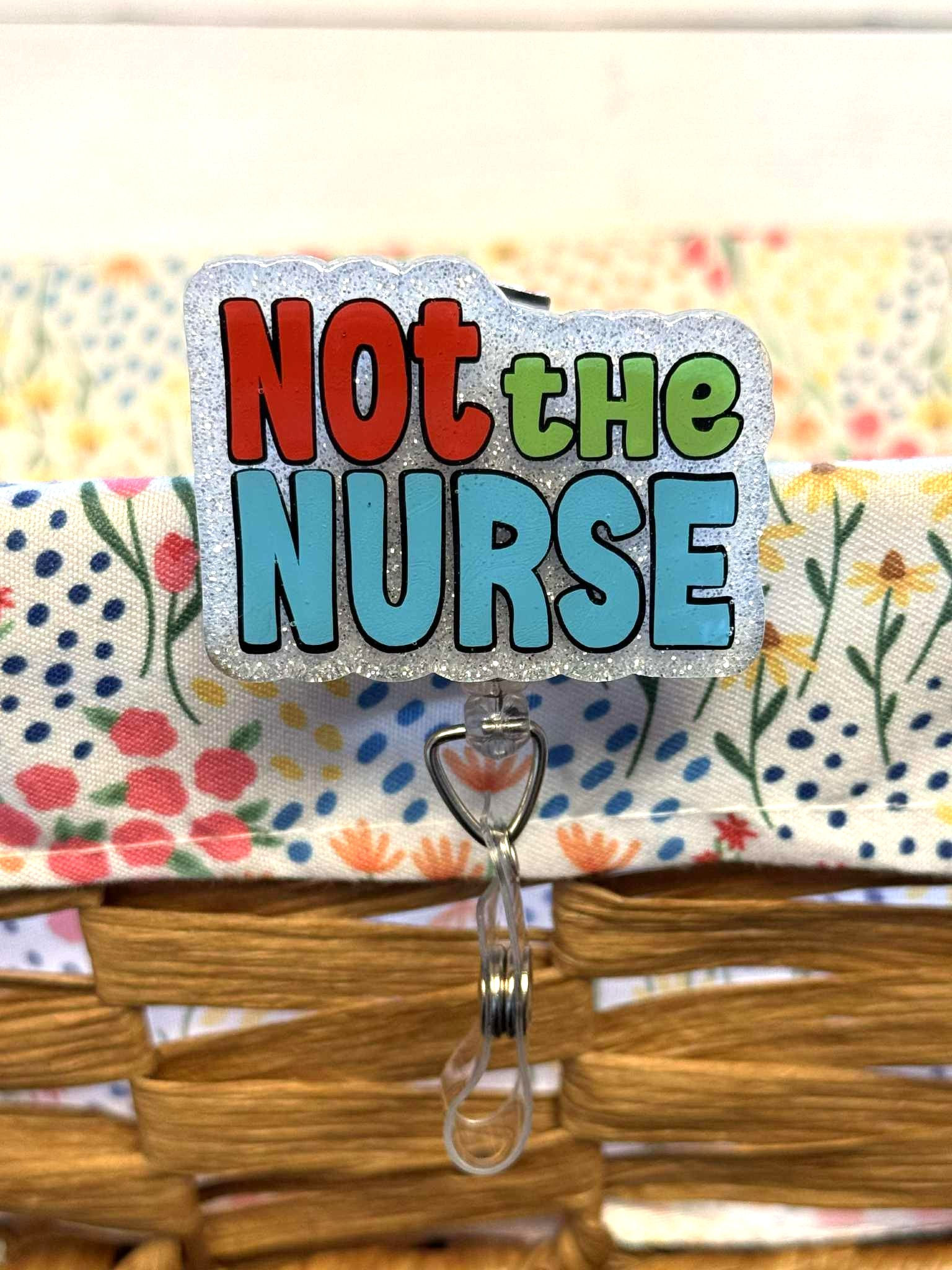 Funny nadge reel that says "Not the Nurse" in bold red, green, and blue text on a glitter background