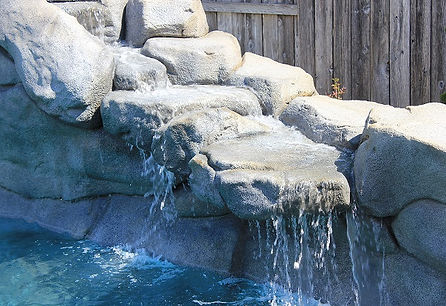 Custom swimming pool with waterfall feature in cool, ca