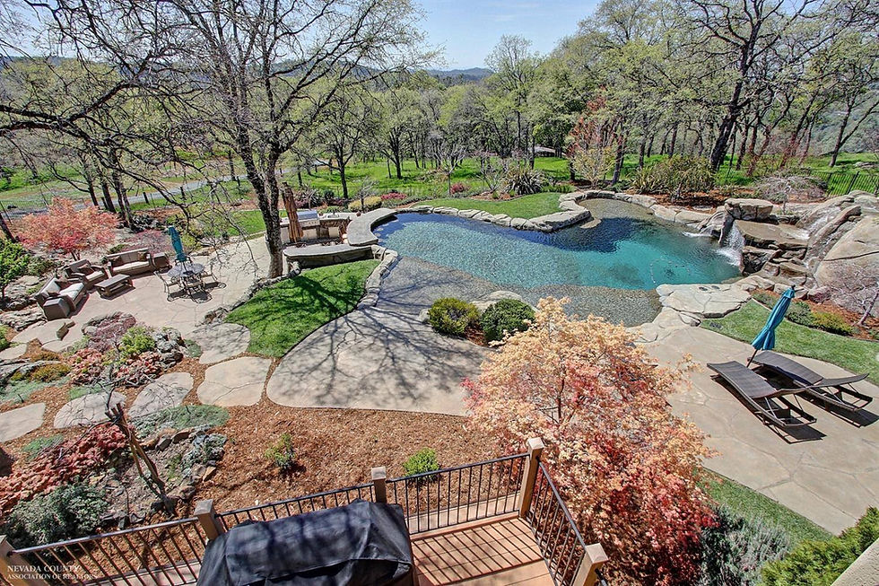 Custom natural rock swimming pool with attached spa, waterfalls, and lagoon-style design built by Yuba River Swimming Holes and Pools in Auburn, Grass Valley, and Northern California, creating a luxury backyard retreat inspired by the Yuba River.