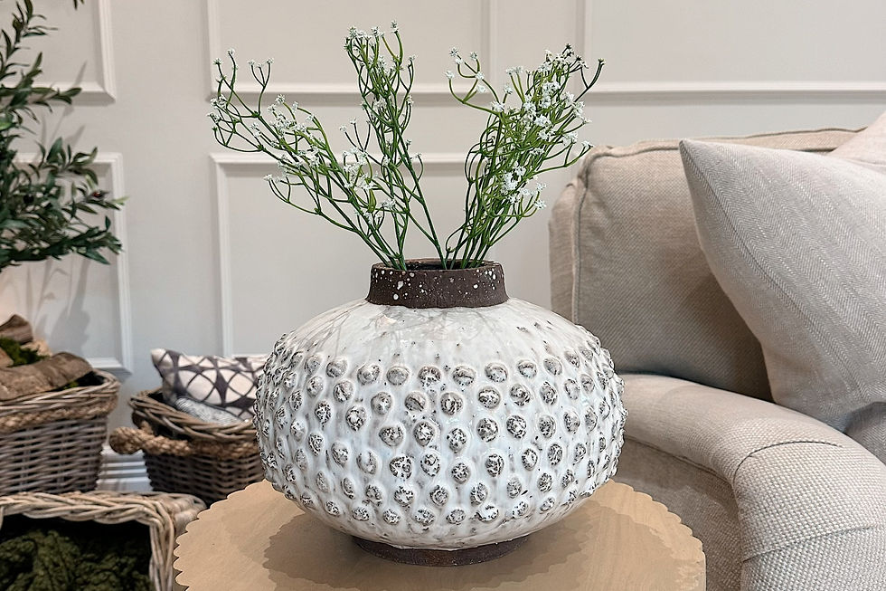 High angle view of a whimsical textured vase with dried flowers