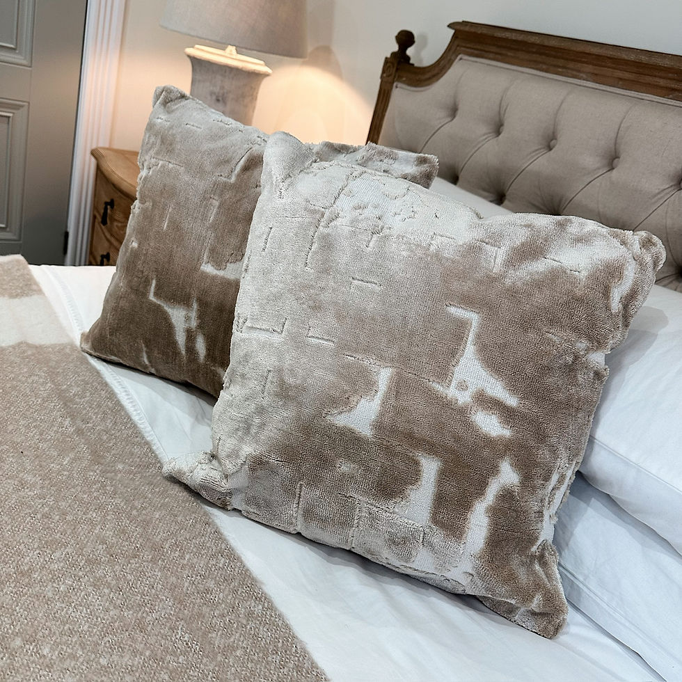 2 HUSLIA beige cushion styled on a bed.