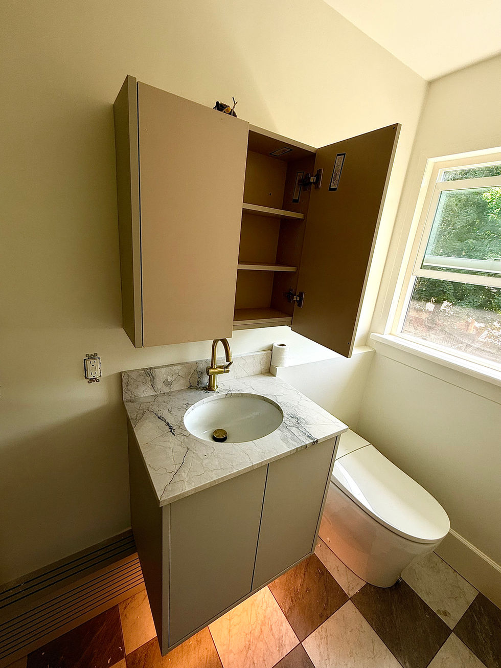 Floating grey vanity with Carrara marble countertop, brass gooseneck faucet, and matching wall-mounted medicine cabinet in a modern powder room