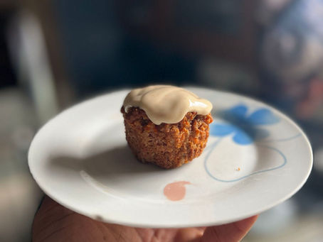 Grain free morning glory muffins on a plate with cinnamon and carrots and icing