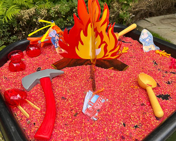 Fire-themed sensory play tray with tools and fire props